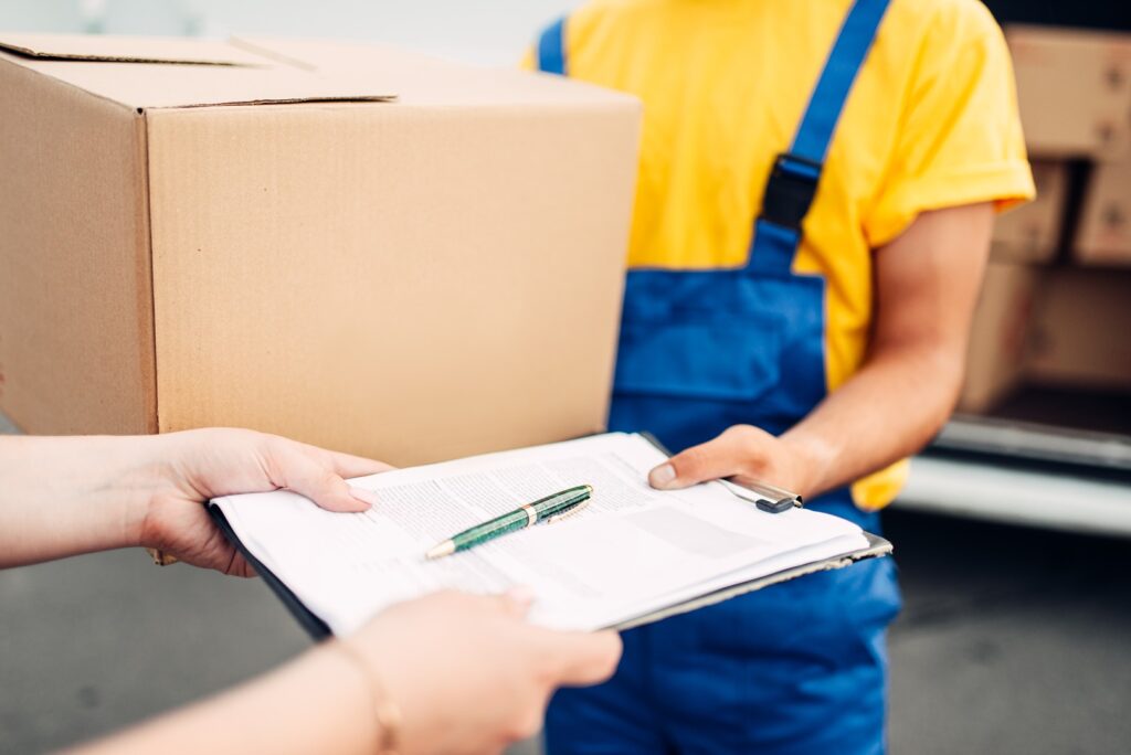 male worker in uniform gives parcel to the client PJR9DY5
